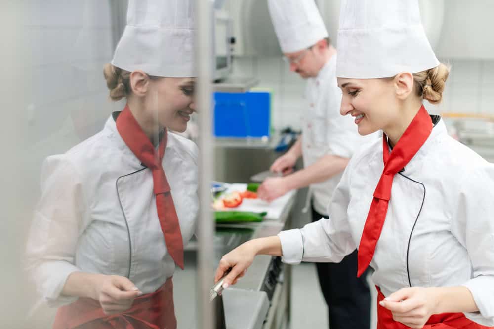 Chef cooking in a kitchen near a commercial grease trap